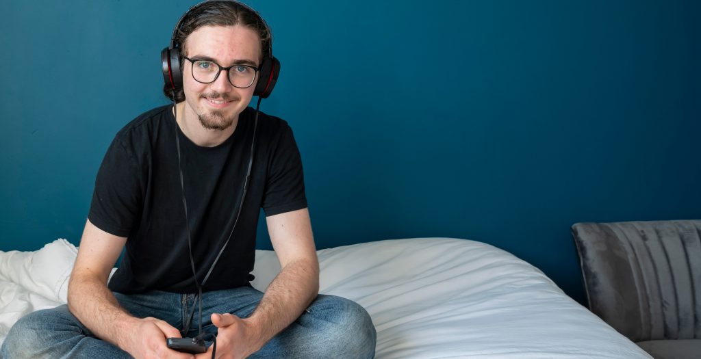 Daniel sat on his bed listening to music