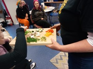 Food being handed out on a chopping board to residents to taste