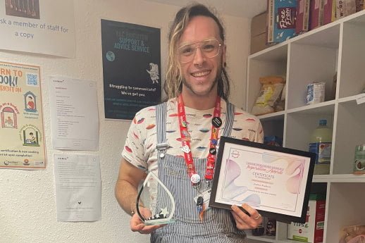 Joshana holding a certificate and glass award