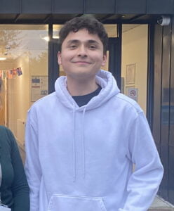 One of our Youth Matters Awards nominees, Randy, smiling in a hoody outside a YMCA building