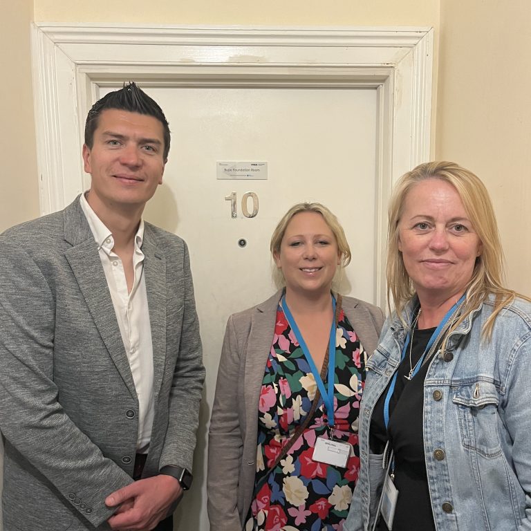 Representatives from Bupa corporate partners, smiling outside their sponsored room in Brighton.