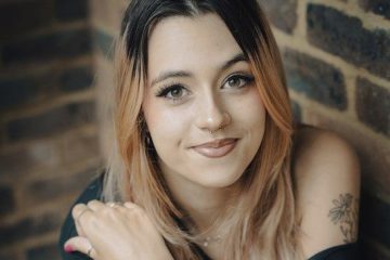 Young woman with brick wall background