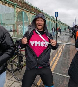 man at the London to Brighton cycle ride finish line displaying YMCA top