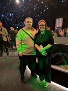 young person and adult stood in a lit up reception venue