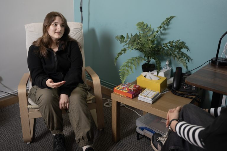 a seated young person talking to another person off-screen