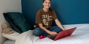 Room sponsorship - Becky sat on bed