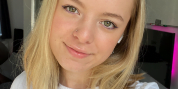 Mollie wearing a white shirt smiling taking a selfie