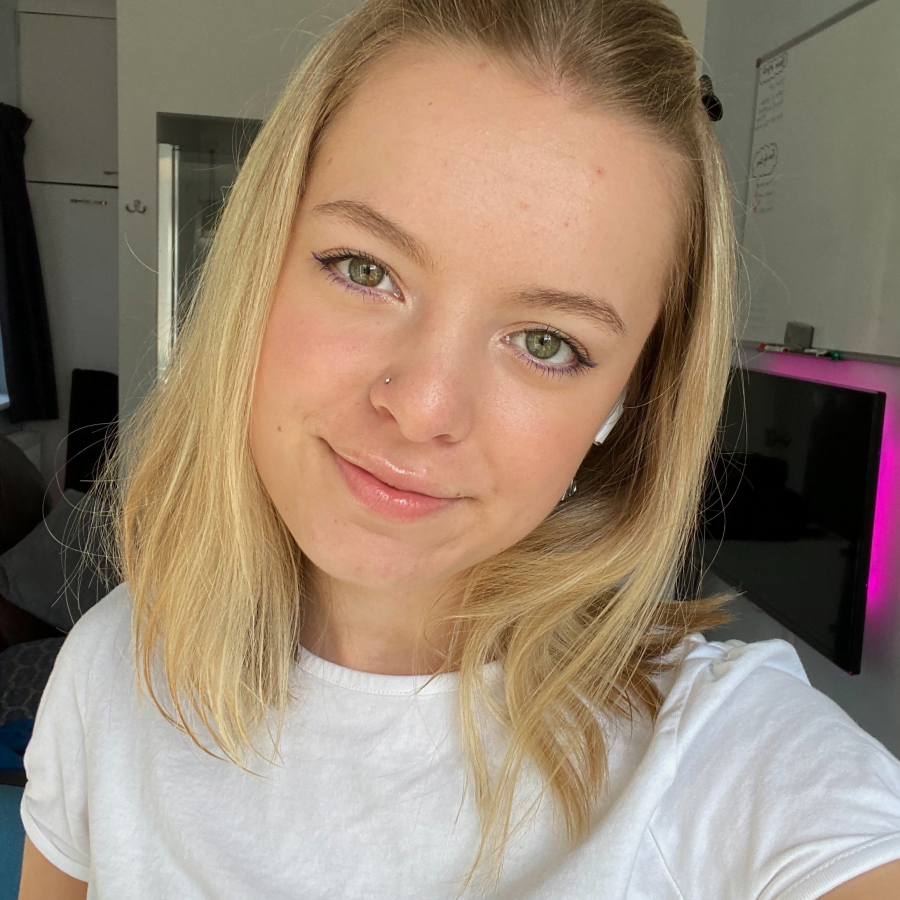 Mollie wearing a white shirt smiling taking a selfie