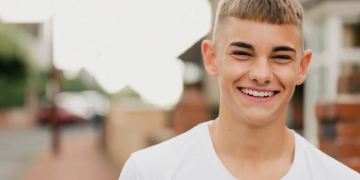 Young man archie smiling on a street