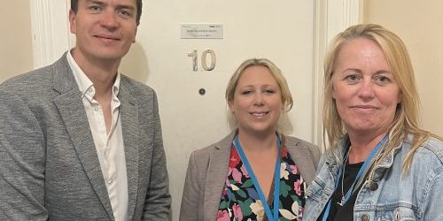 Representatives from Bupa corporate partners, smiling outside their sponsored room in Brighton.